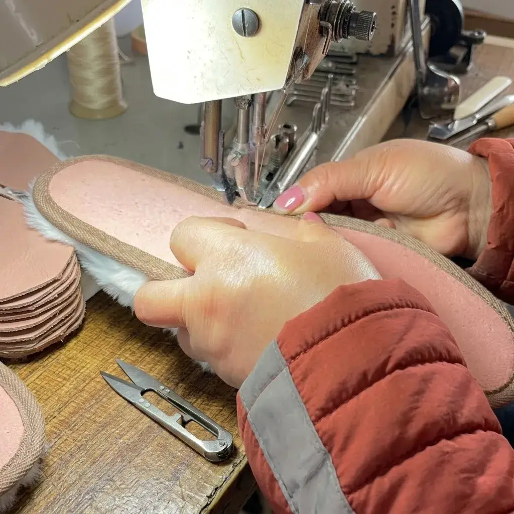 Close-up of the professional welt-stitched sewing process for high-quality Wholesale Indoor Slippers in a Chinese factory, highlighting precision craftsmanship.