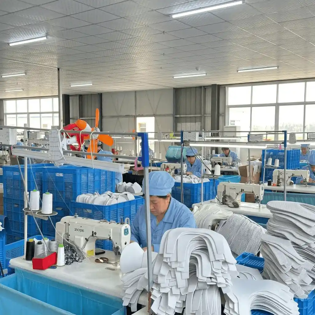 Clean and highly organized factory workspace with skilled workers at parallel sewing machines, demonstrating high-volume capacity for house slippers in bulk.