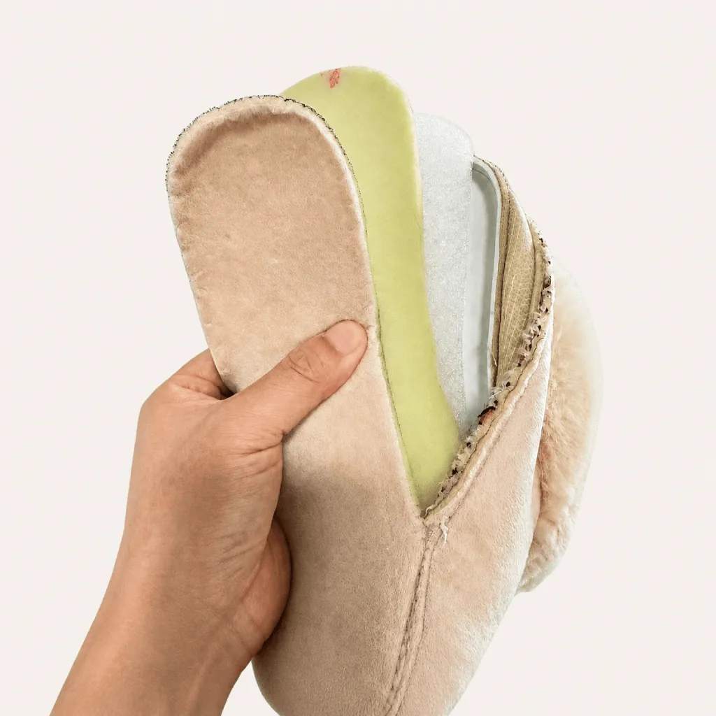 Opened memory foam slipper showing the insole cover, memory foam layer and supporting cushioning layers
